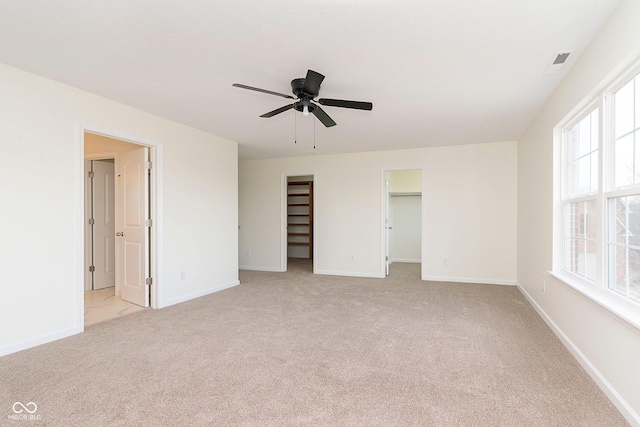 unfurnished bedroom featuring baseboards, visible vents, and light colored carpet