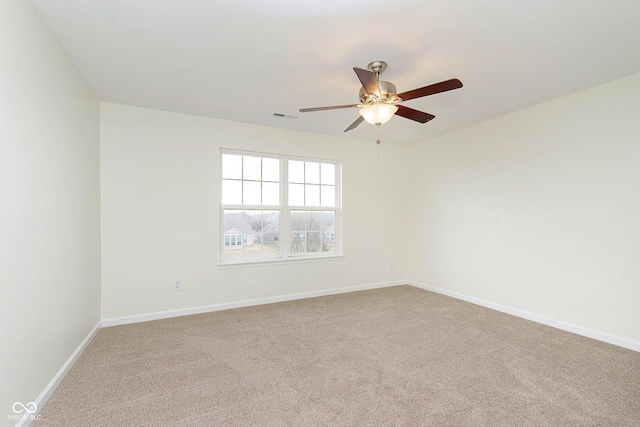 carpeted empty room with a ceiling fan, visible vents, and baseboards