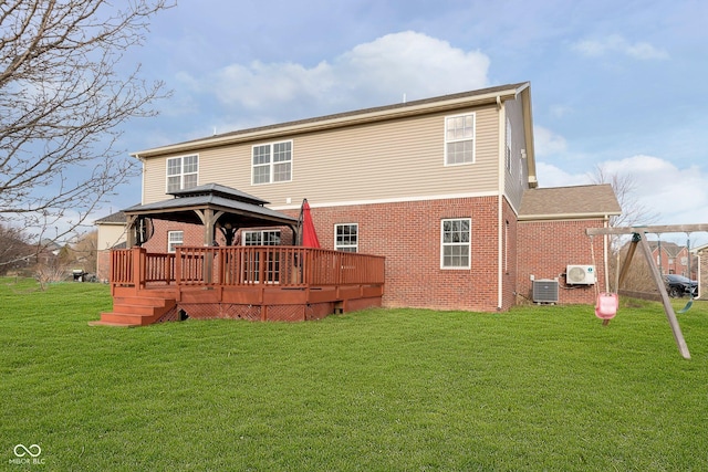 rear view of property featuring a yard, brick siding, central AC unit, and a gazebo