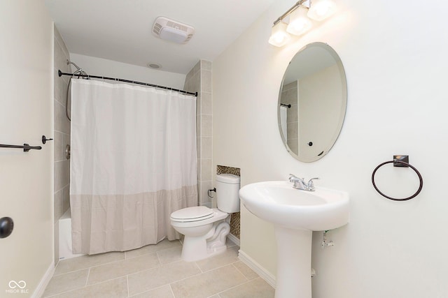 bathroom featuring toilet, shower / tub combo, visible vents, baseboards, and tile patterned floors