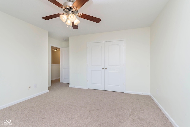 unfurnished bedroom with baseboards, a closet, a ceiling fan, and light colored carpet