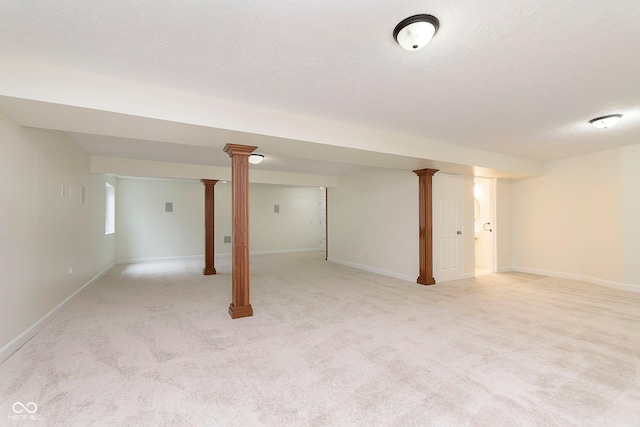 finished below grade area featuring baseboards, a textured ceiling, and light colored carpet