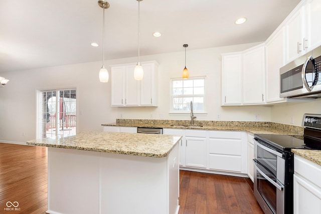 kitchen featuring stainless steel appliances, dark wood-style flooring, a sink, white cabinets, and a center island