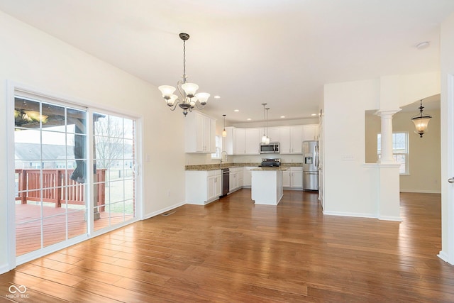 kitchen with stainless steel appliances, dark wood-style flooring, a notable chandelier, and open floor plan