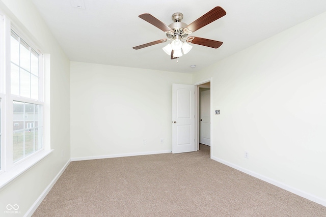 spare room featuring carpet floors, ceiling fan, and baseboards