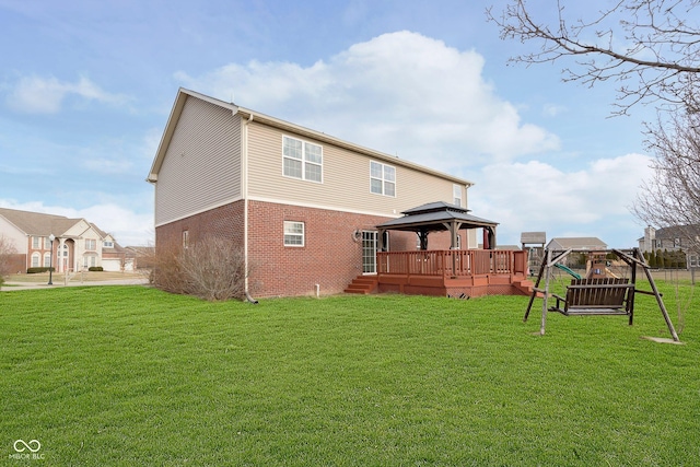 back of house with a gazebo, a yard, and brick siding