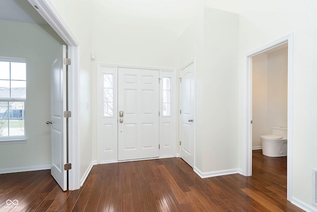 foyer featuring visible vents, baseboards, and dark wood-style flooring