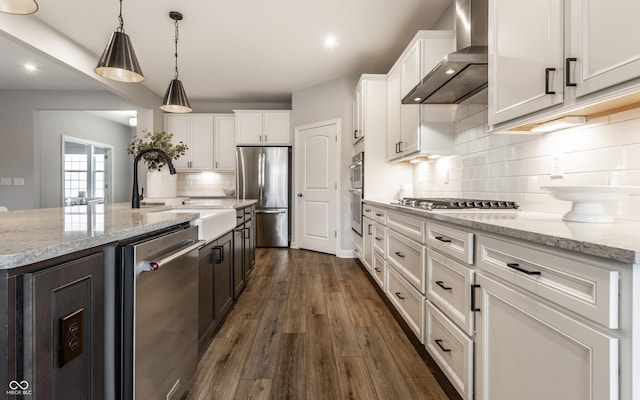804 Whispering Oaks Dr, Carmel, IN 46032 - kitchen featuring wall chimney range hood, appliances with stainless steel finishes, white cabinets, a sink, and dark wood finished floors