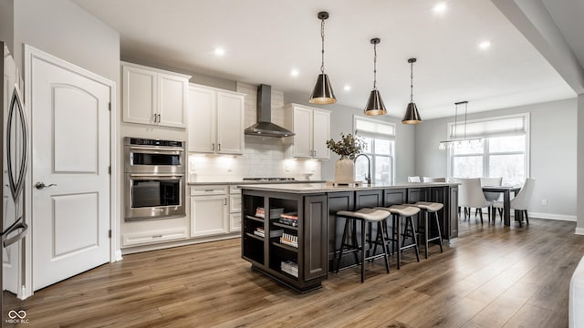 804 Whispering Oaks Dr, Carmel, IN 46032 - kitchen with wall chimney range hood, double oven, open shelves, a kitchen bar, and white cabinets