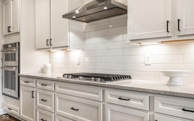 804 Whispering Oaks Dr, Carmel, IN 46032 - kitchen featuring wall chimney range hood, stainless steel appliances, decorative backsplash, and white cabinets