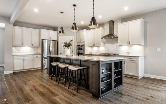 804 Whispering Oaks Dr, Carmel, IN 46032 - kitchen with wall chimney range hood, stainless steel appliances, baseboards, dark wood-type flooring, and recessed lighting