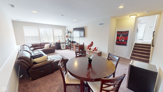 carpeted dining space featuring baseboards, stairway, visible vents, and recessed lighting