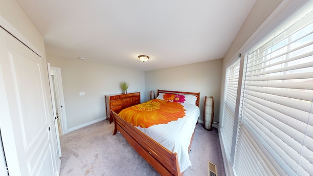 bedroom with light carpet, visible vents, and baseboards