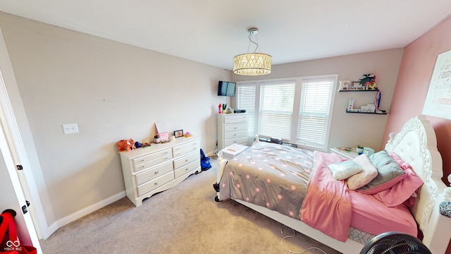 bedroom with light carpet, baseboards, and a chandelier