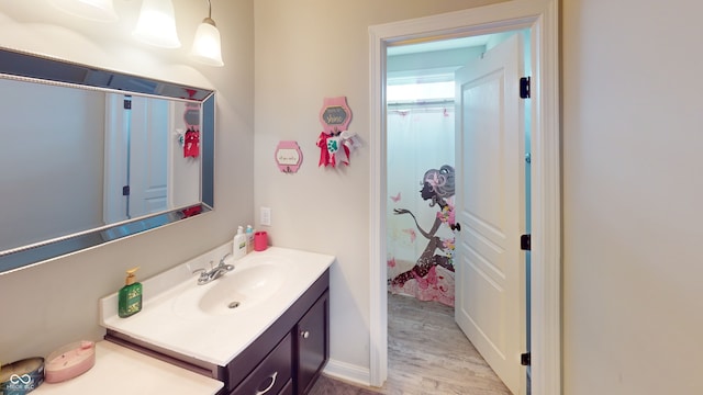 bathroom featuring curtained shower, wood finished floors, and vanity