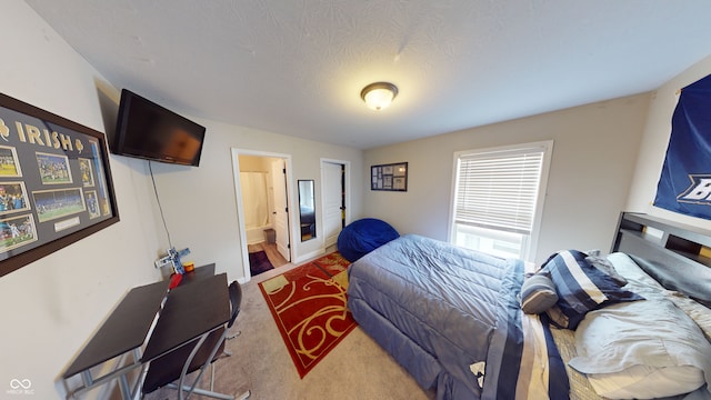 bedroom featuring carpet flooring, a textured ceiling, and ensuite bathroom