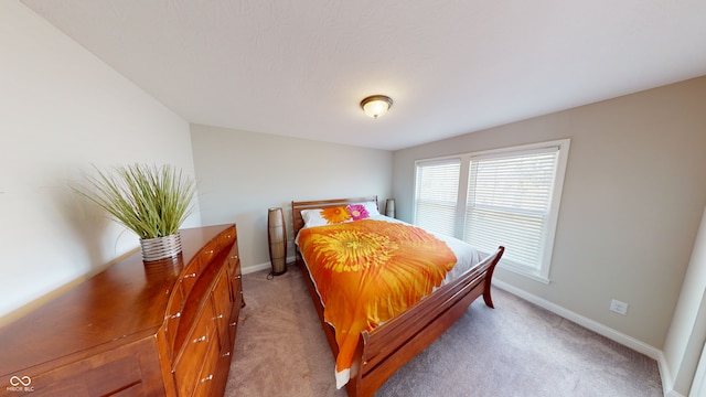 bedroom with baseboards and light colored carpet