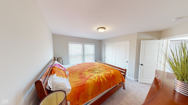 bedroom with carpet floors, baseboards, and a closet