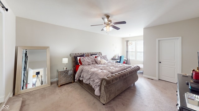 bedroom featuring a barn door, baseboards, ceiling fan, and light colored carpet