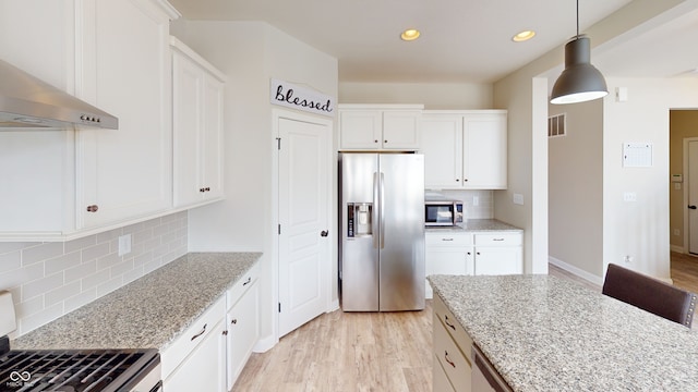 kitchen featuring visible vents, wall chimney exhaust hood, light wood-style flooring, appliances with stainless steel finishes, and white cabinetry