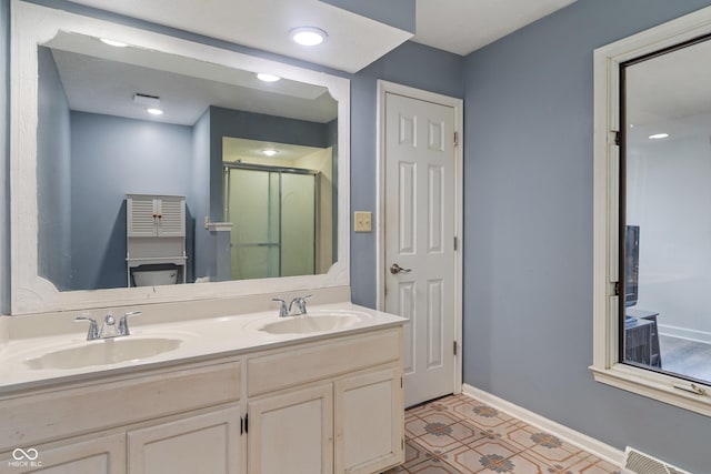 full bathroom with a stall shower, baseboards, visible vents, and a sink