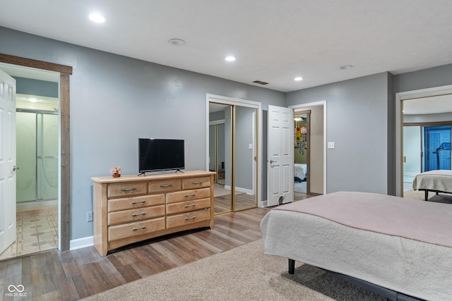 bedroom with recessed lighting, visible vents, baseboards, and wood finished floors