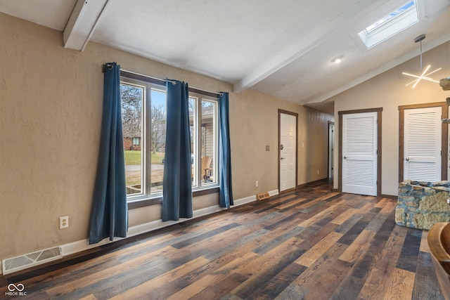 interior space featuring vaulted ceiling with skylight, visible vents, plenty of natural light, and wood finished floors