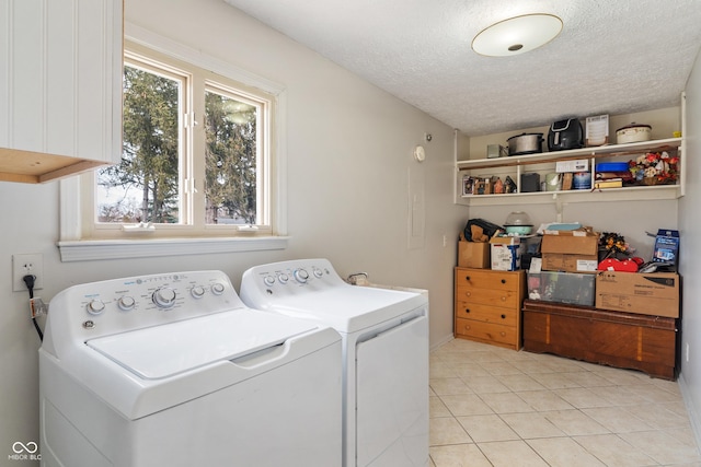 washroom with washer and dryer, laundry area, light tile patterned flooring, and a textured ceiling