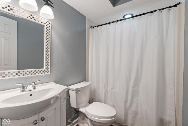 full bath featuring a textured ceiling, a textured wall, toilet, vanity, and a shower with curtain