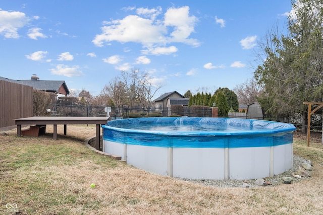 view of swimming pool with a yard, fence, and a fenced in pool