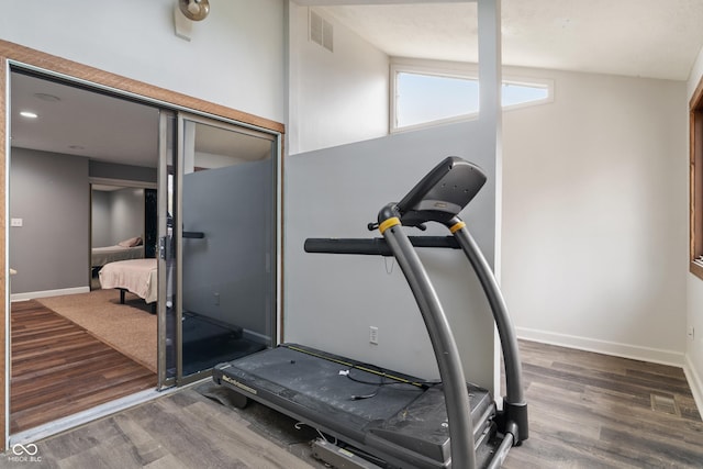 exercise room featuring visible vents, baseboards, and wood finished floors