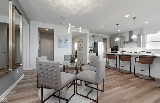 dining area with light wood finished floors, baseboards, a notable chandelier, and recessed lighting