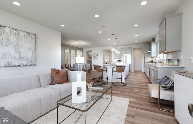 living area featuring recessed lighting, visible vents, and light wood finished floors