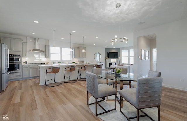 dining room featuring a healthy amount of sunlight, light wood-style floors, and recessed lighting