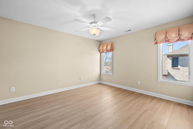 unfurnished room featuring baseboards, ceiling fan, visible vents, and light wood-style floors