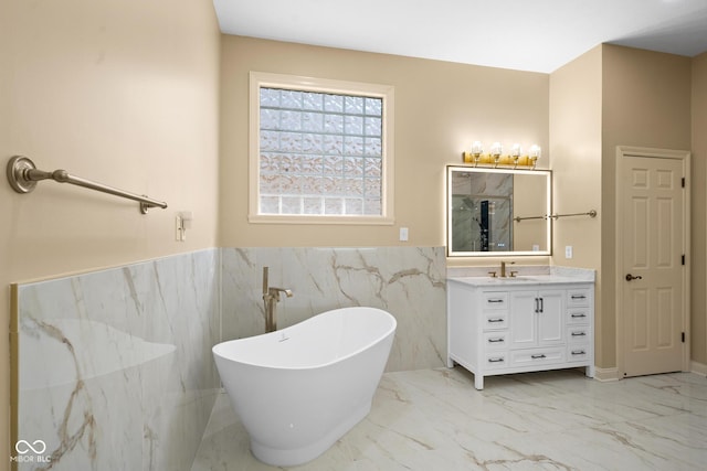 bathroom featuring marble finish floor, a freestanding tub, vanity, and a marble finish shower