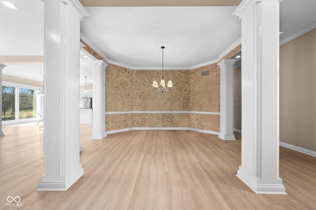 unfurnished dining area with baseboards, wallpapered walls, ornamental molding, and ornate columns