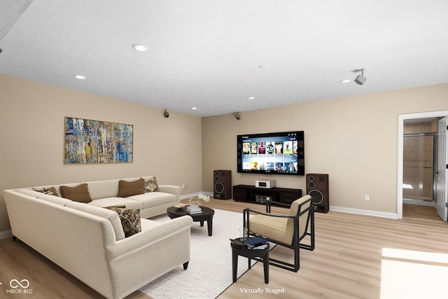 living room with light wood-style floors, recessed lighting, and baseboards