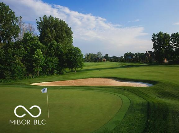 view of home's community featuring golf course view and a lawn