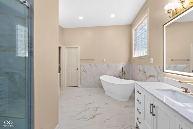 full bathroom with a stall shower, marble finish floor, vanity, a freestanding tub, and recessed lighting