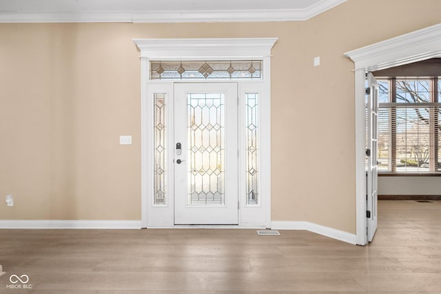 entrance foyer with light wood-style flooring, baseboards, and crown molding