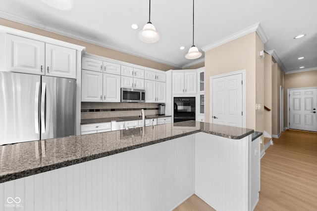 kitchen with white cabinetry, light wood-style flooring, ornamental molding, and stainless steel appliances