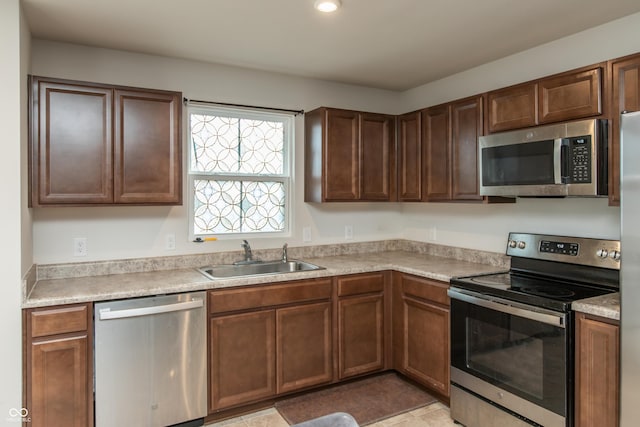 kitchen featuring stainless steel appliances, a sink, and light countertops