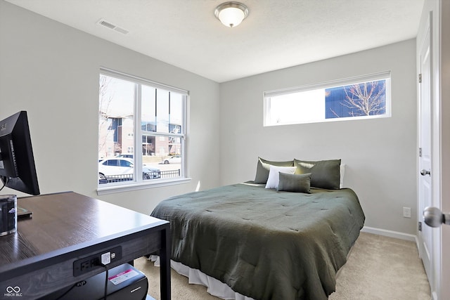 bedroom with visible vents, light colored carpet, and baseboards