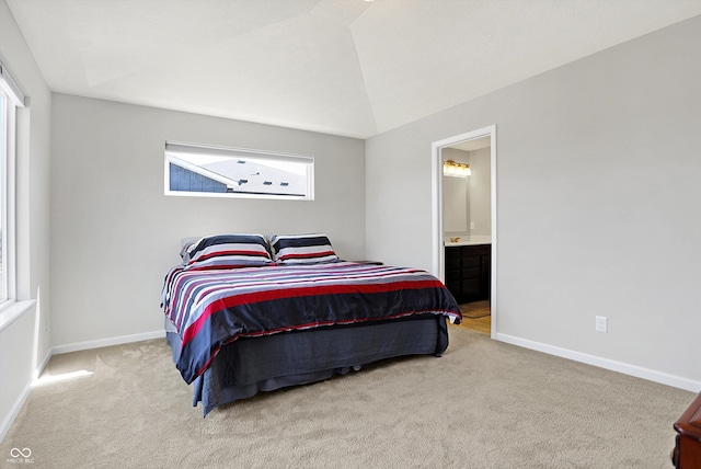 bedroom with lofted ceiling, ensuite bathroom, baseboards, and carpet floors