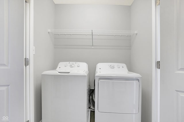 clothes washing area with washing machine and dryer and laundry area