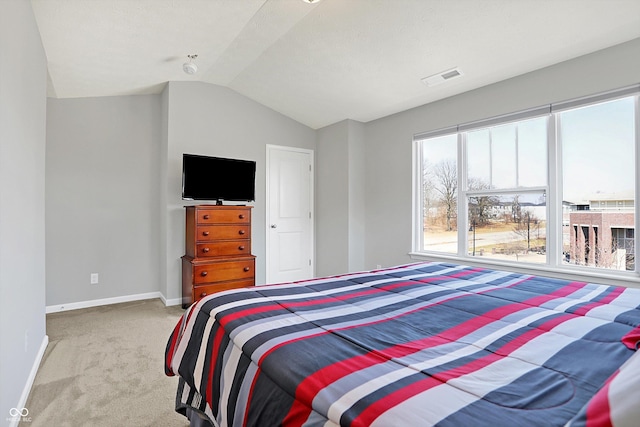 carpeted bedroom featuring lofted ceiling, baseboards, and visible vents