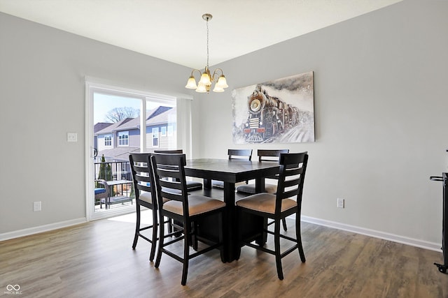 dining area with wood finished floors, baseboards, and a chandelier