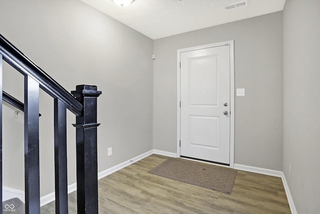 entrance foyer with visible vents, baseboards, and wood finished floors