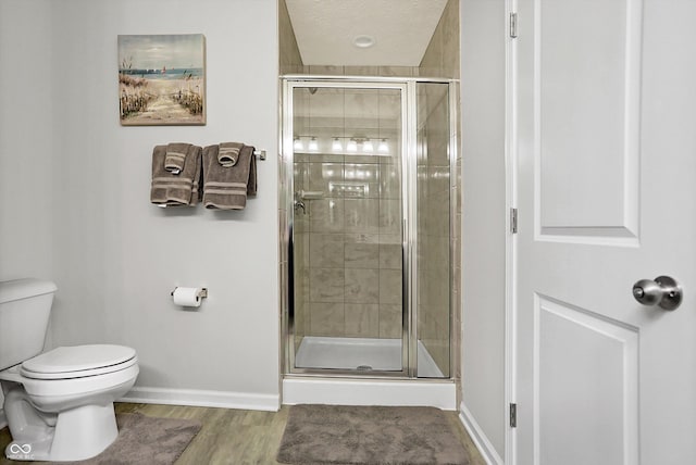 full bathroom featuring a stall shower, toilet, and baseboards